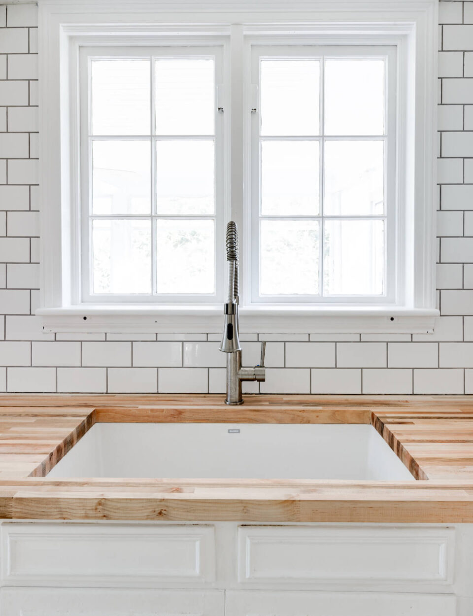wood counters, undermount sink, and subway tile
